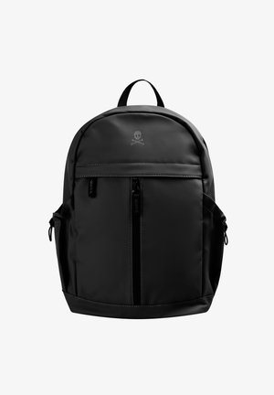 Mochila negra con una textura suave, que presenta un bolsillo frontal con cremallera, bolsillos laterales y un logo de calavera y huesos cruzados. Diseño simple y redondeado.