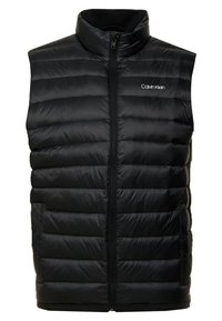 Czarna pikowana kamizelka z wysokim kołnierzem, zamkiem z przodu i bocznymi kieszeniami. Posiada pikowaną strukturę oraz biały napis "Calvin Klein".