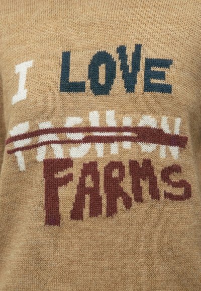 Pleten pulover v bež barvi z kontrastnim napisom: "I LOVE FASHION" v temno modri barvi in "FARMS" v globoko rdeči, delno prečrtano. Mehka tekstura.