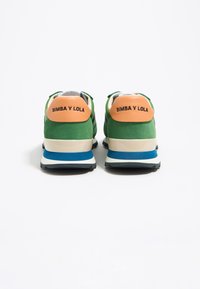 Zielono-czarne trampki z teksturowanym zamszowym wierzchem, białą i niebieską podeszwą oraz pomarańczową pętlą na pięcie z napisem "BIMBA Y LOLA" w czarnych literach.