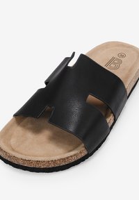 Black leather slide sandal with a wide U-shaped strap, cork footbed, and textured rubber outsole. Size 36 indicated on the insole.