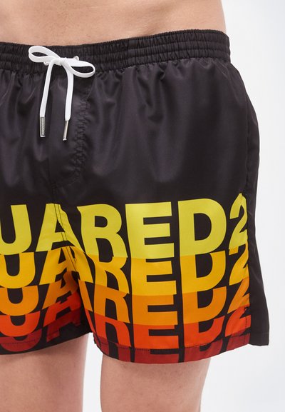 Μαύρα μαγιό σορτς με μεγάλο κείμενο σε κλίση από κίτρινο σε κόκκινο, ελαστική μέση με λευκό κορδόνι και ελαφρύ ύφασμα.