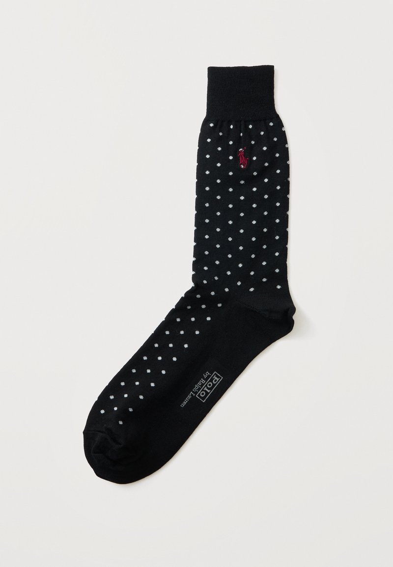Chaussette noire à pois blancs, bord-côte, logo rouge brodé près du haut et texte blanc "Polo by Ralph Lauren" sur la semelle du pied.