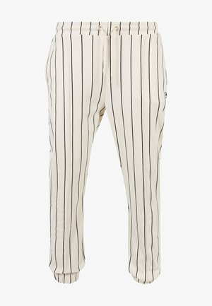 Weiße Hose mit schwarzen vertikalen Streifen, ausgestattet mit einem elastischen Bund und einem Kordelzug sowie umschlagenen Säumen. Weicher Stoff.