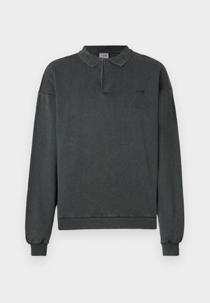 Tricou polo gri închis cu mânecă lungă, guler fără nasturi, manșete și tiv striate, cu un mic logo negru pe partea stângă a pieptului.