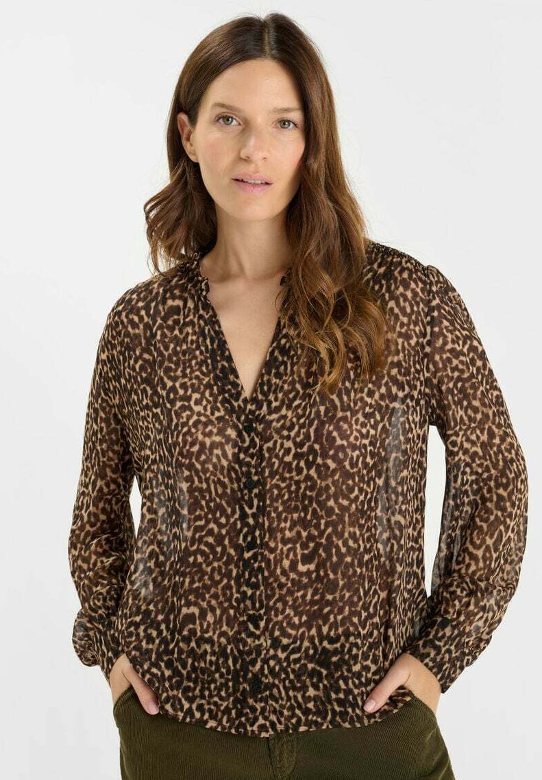Leopard print blouse made of sheer fabric. Features a button-down front, long sleeves, and a loose fit that gathers slightly at the cuffs.
