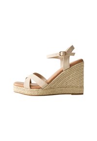Sandales à talons compensés beiges avec des brides entrecroisées, une boucle à la cheville et une plate-forme en jute texturé. Tige en cuir lisse et semelle intérieure rembourrée.