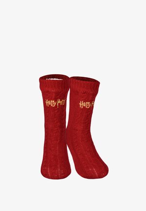 Paar rote gestrickte Socken mit Zopfmustern, mit dem gelben Schriftzug "Harry Potter" nahe der oberen Bündchenkante bestickt.