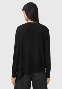 Maglione nero con maniche lunghe, scollo a giro e una vestibilità leggermente oversize, con orlo a coste e spacchi laterali.