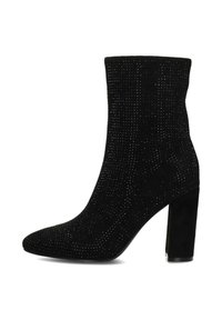 Botte noire à cheville avec un design cannelé texturé, un bout pointu et un talon épais. Le matériau semble doux et semblable à du daim, avec des embellissements subtils.