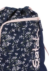 Floral drawstring bag with a navy background, featuring white flower patterns, pink zipper, and logo detail on the side. Fabric texture visible.