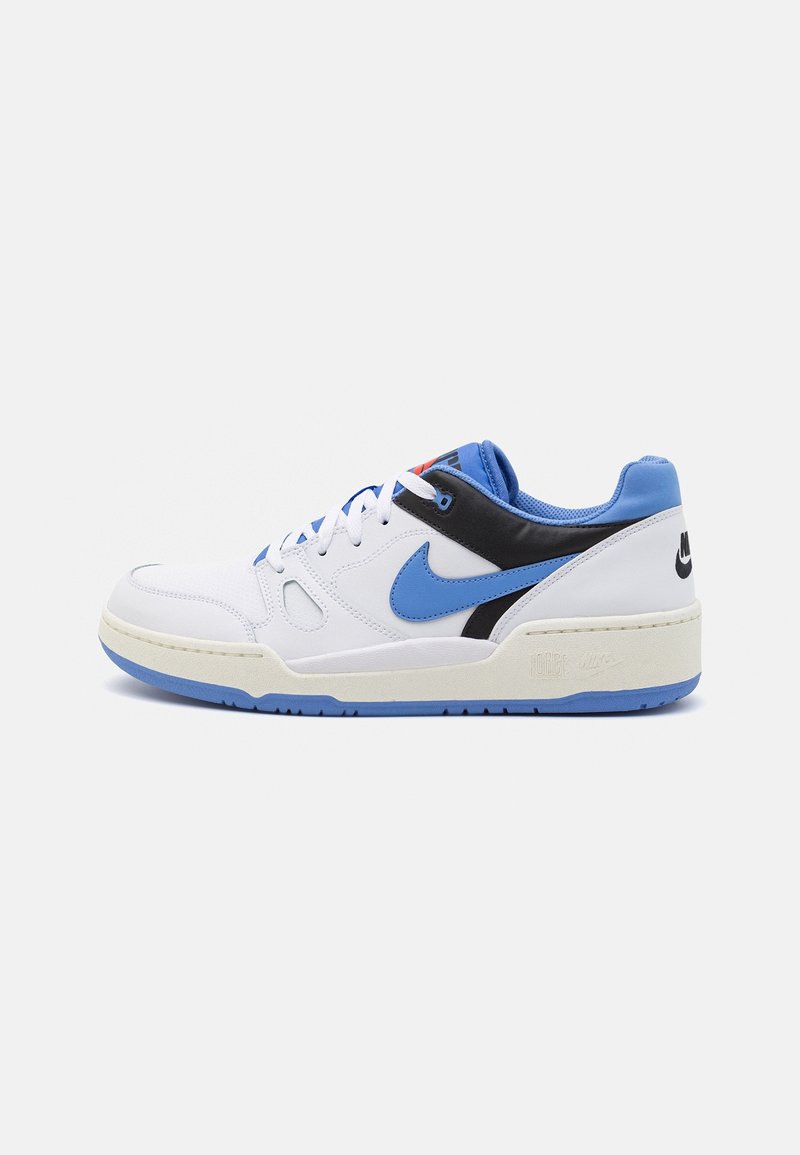 Baskets basses Nike blanches et bleues avec des accents noirs, des lacets blancs et un logo Nike bleu sur le côté.