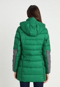 Grön puffjacka med huva, med en kviltad design, grå detaljer på ärmarna och en glänsande, slät textur.