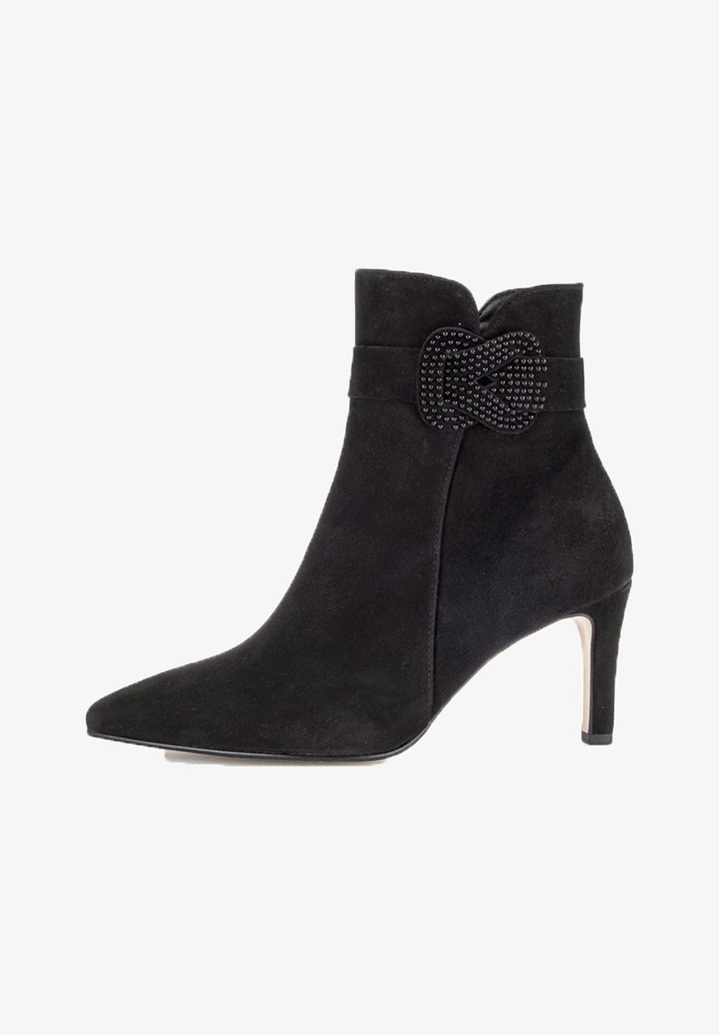 Bottine noire en suede avec un talon aiguille de 8 cm, bout pointu et accent décoratif en bijou noir sur le côté. Texture lisse tout au long.