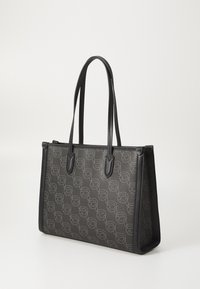 Juodas kelioninis krepšys, pagamintas iš tekstūruoto medžiagos, su pasikartojančiu šviesiai pilku raštu. Sustiprinti kampai ir dvigubos petnešos užbaigia dizainą.