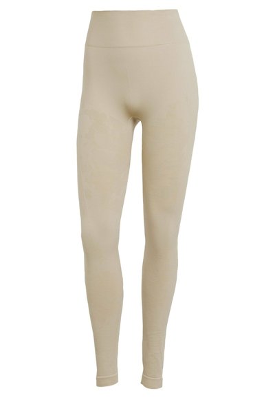 Leggings beige realizzati in un materiale morbido e elasticizzato. Vita alta e texture liscia con un design sottile lungo le gambe. Vestibilità a lunghezza intera.