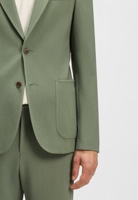 Lichtgroene blazer van gestructureerde stof met een klassieke reverskraag, enkele knoopsluiting en een borstzak, gecombineerd met bijpassende broek.