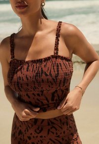 Bruin en zwart patroon smock top met dikke gerimpelde bandjes, gecombineerd met een bijpassende high-waisted onderkant. Gladde textuur, aansluitend ontwerp.