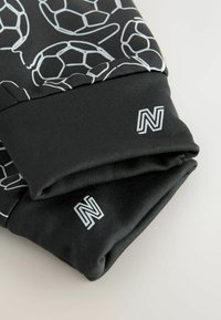 Schwarzer Stoff mit weißem Fußballmuster, mit enger Passform und Logodetails. Entworfen für Sport- oder Freizeitkleidung.