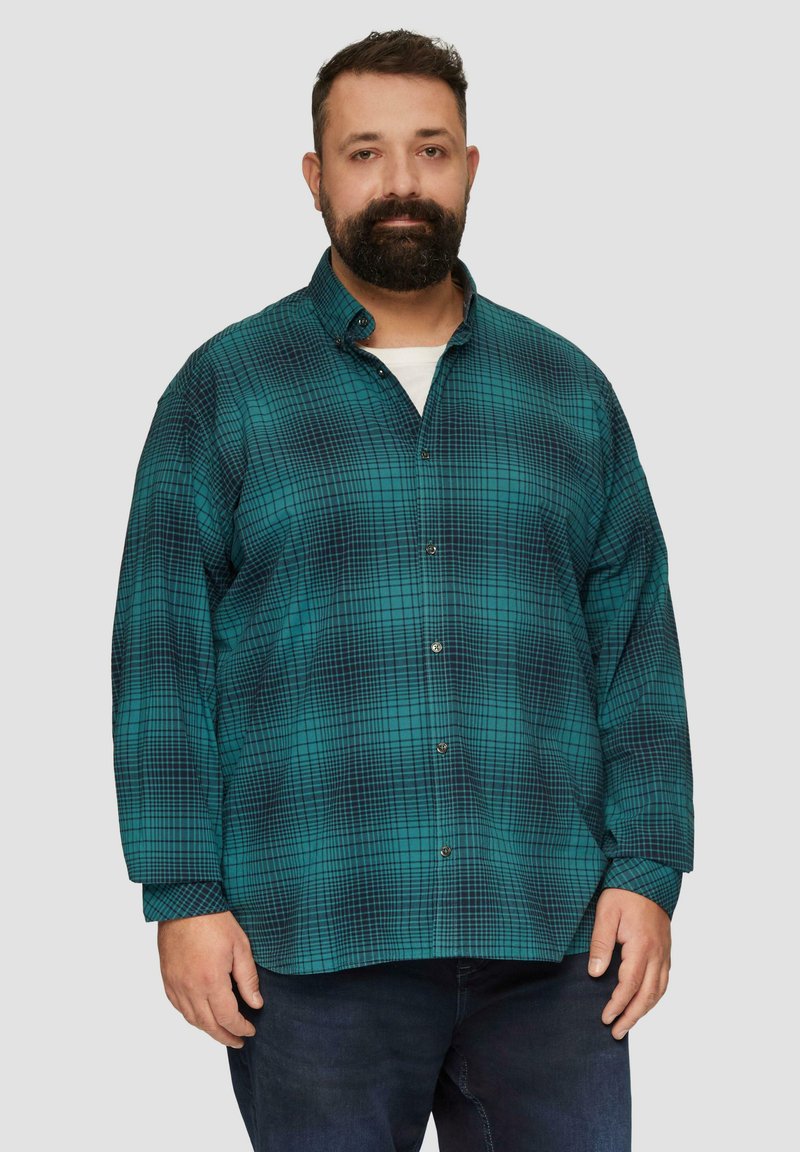 Langärmliges Hemd in Türkis mit einem dunklen karrierten Muster, ausgestattet mit einem Kentkragen und metallischen Knöpfen, getragen über einem weißen Hemd.