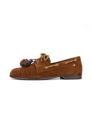 Mocasín de ante marrón con cordones de cuero y adorno de borlas, tacón plano y detalles cosidos a lo largo de la puntera y los laterales.