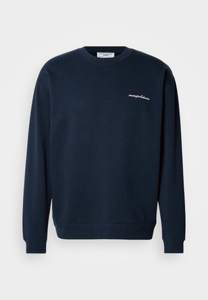 Marineblauer Pullover aus weichem Stoff mit Rundhalsausschnitt, langen Ärmeln und einer kleinen weißen Stickerei auf der Brust.