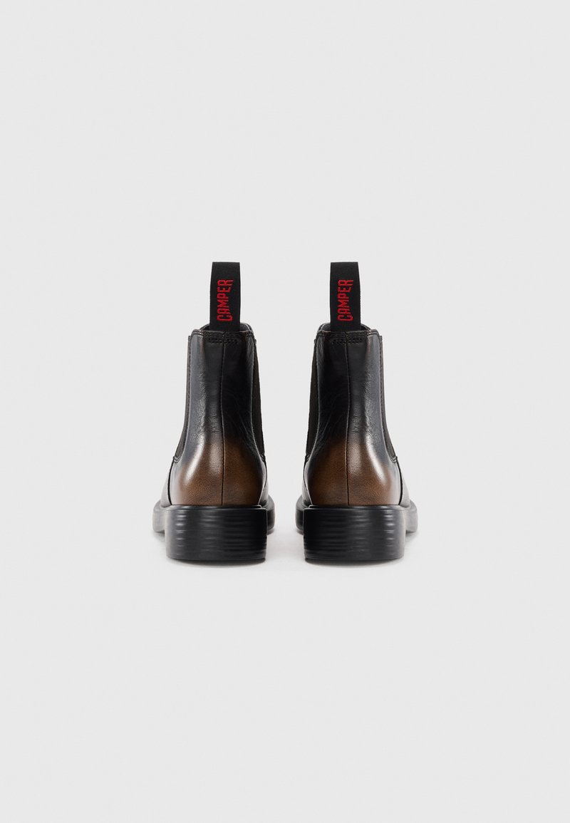 Pair of black and brown leather Chelsea boots with black soles and red "CAMPER" pull tabs, viewed from the back on a white background.