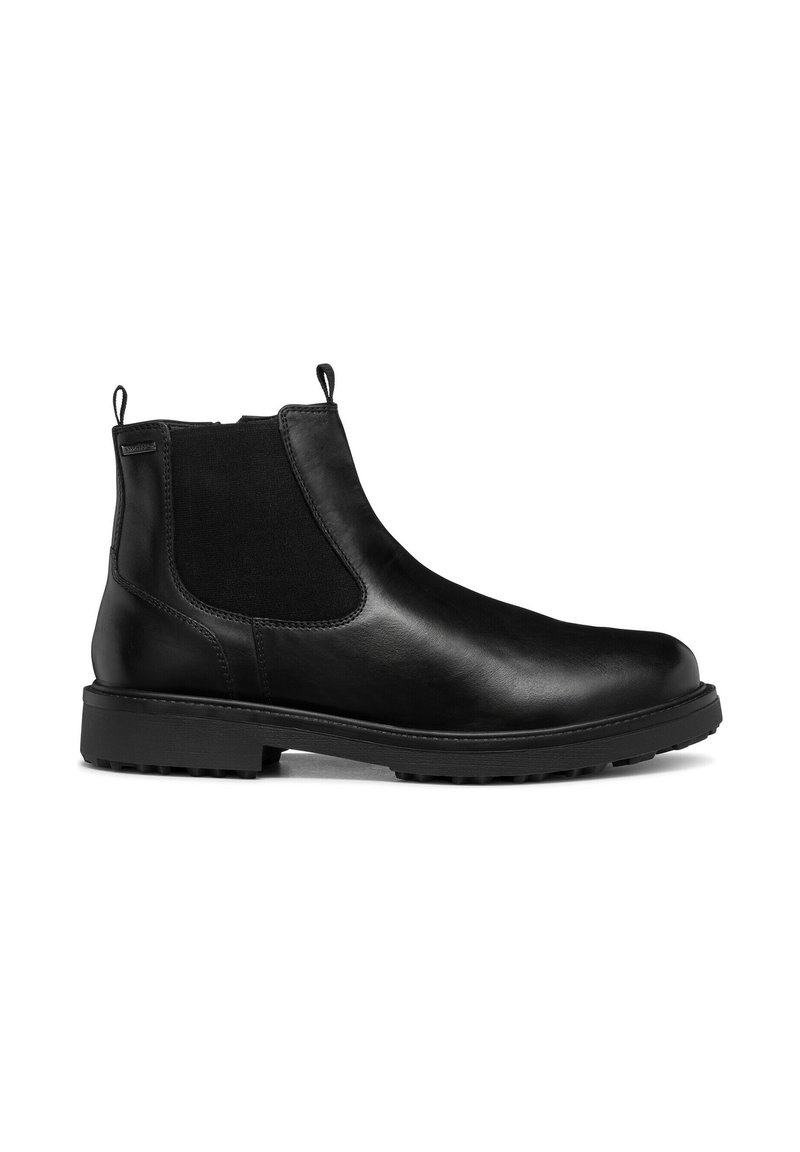 Botas de tobillo de cuero negro con paneles laterales elásticos, punta redondeada y tiradores; suela texturizada para tracción. Diseño minimalista.