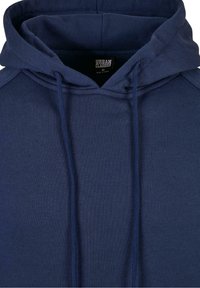 Sweat à capuche bleu marine avec cordon de serrage, coupe décontractée et texture douce, confectionné dans un tissu léger, avec une étiquette intérieure visible.