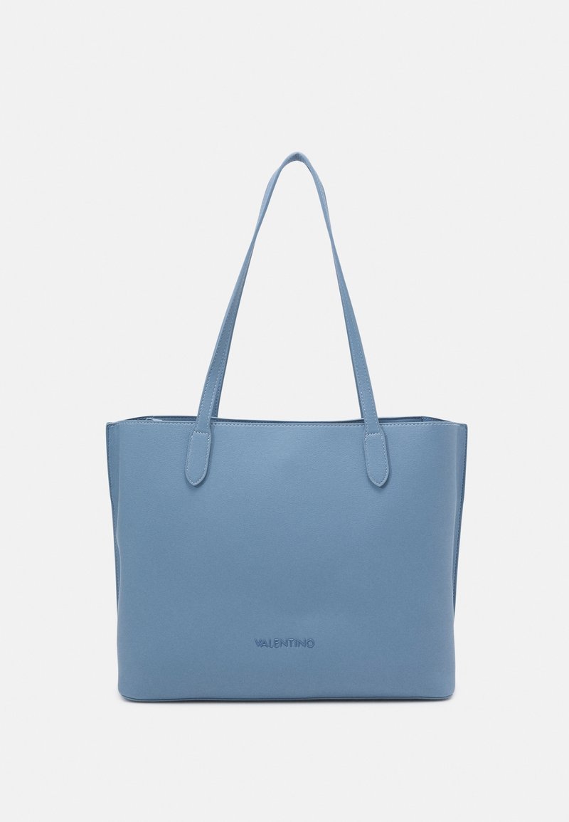 Tote-väska i ljusblått läder, med två handtag, minimalistisk design och präglad logotyp fram.