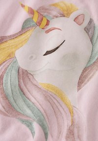 Graphique de licorne sur un fond rose pr�ésentant la tête d'une licorne blanche, avec une corne rayée d'or et de rouge et une crinière fluide aux couleurs pastel.