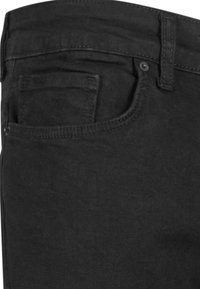 Jeans de mezclilla negra con un diseño clásico de cinco bolsillos, cierre de cremallera y sutilezas en los detalles de las costuras. Textura suave.