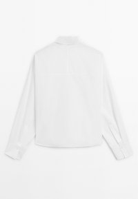 Hvid langærmet skjorte med klassisk krave, lige søm og knappede manchetter. Glat tekstur, minimalistisk design, ingen mønstre eller accenter.