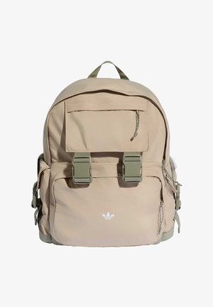 Béžový batoh Adidas s předním kapsou se klopou, dvěma zelenými přezkami, bočními kapsami a zapletenými přívěsky na zip.