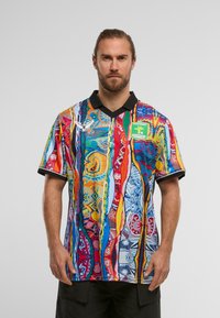 Večbarvna športna majica z izrazitim vzorcem v modri, rdeči, rumeni in zeleni barvi, črn ovratnik in podrobnosti logotipa spredaj.