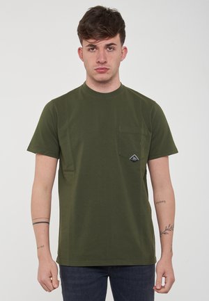 T-shirt corta a maniche corte verde oliva, scollatura rotonda, tasca frontale con una toppa logo triangolare sul lato sinistro. Materiale in morbido cotone.