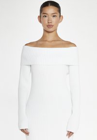 Abito bianco a spalla scoperta con maniche lunghe e tessuto testurizzato. Silhouette aderente, design a metà lunghezza con scollatura dritta.