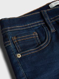 Mørkeblå denimjeans med oransje sømmer, med en liten myntlomme og et belteetikett. Glatt tekstur og klassisk fem-lomme-design.