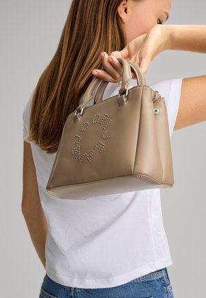 Beige faux læder håndtaske med sølv accenter og rhinsten bogstaver. Har dobbelte håndtag og en struktureret design.