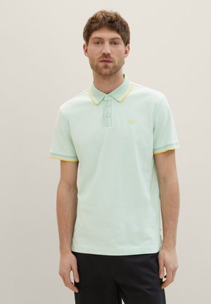 Hellgrünes Poloshirt mit gelbem Kragen und Ärmelsaum, ausgestattet mit einer Drei-Knopf-Leiste und einem kleinen Logo auf der Brust.
