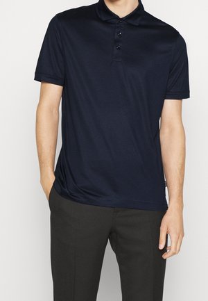 Navyblaues Poloshirt mit kurzen Ärmeln, Drei-Knopf-Leiste und weicher Textur; bietet einen lässigen Schnitt und einen leichten Glanz.