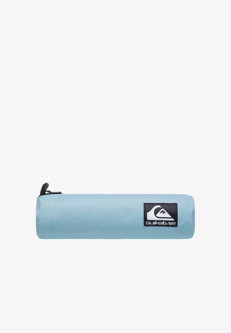 Lysblå cylindrisk penalhus med sort lynlås og Quiksilver-logo patch på siden mod en hvid baggrund.