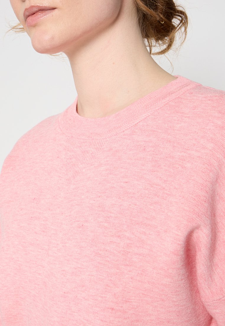 Roze sweatshirt van een textuurstof, met een ronde halslijn en een ontspannen pasvorm. Geen zichtbare logo's of patronen.
