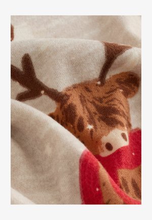 Pehmea beež kangas, millel on pruun põhjapõder punase salliga, nähtav käärides ja lähedal olev tekstuur.