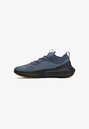 Zapatilla deportiva azul oscuro con parte superior de punto, suela gruesa negra y pestañas para tirar en el talón y la lengüeta, mostrada desde la vista lateral interior.