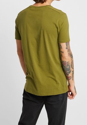 Oliwkowa koszulka z krótkim rękawem, okrągłym dekoltem, wykonana z miękkiej bawełny, o prostym wzorze i luźnym kroju.