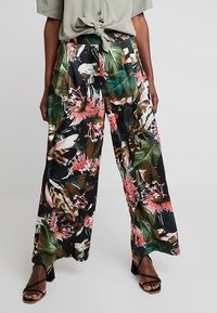 Wijdvallende broek van zwarte stof met een levendige tropische bloemenprint in roze en groene tinten. Lichtgewicht materiaal met een soepele textuur.