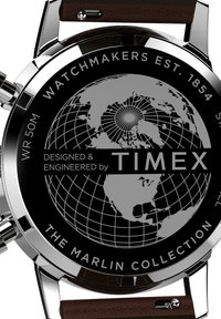 Montre de la collection Timex Marlin avec un boîtier en acier inoxydable, un cadran noir à motif de globe et un bracelet en cuir marron. Résistante à l'eau jusqu'à 50 mètres.