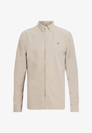 Langsleeve overhemd van lichtbeige stof. Heeft een klassieke kraag, knopen aan de voorkant en een klein geborduurd logo op de borst.