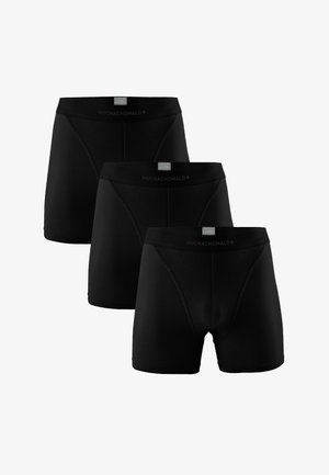 Trzy czarne bokserki męskie ułożone w przesuniętej formie, z etykietami na pasku z napisem "Muchachomalo" oraz "Pima Cotton".